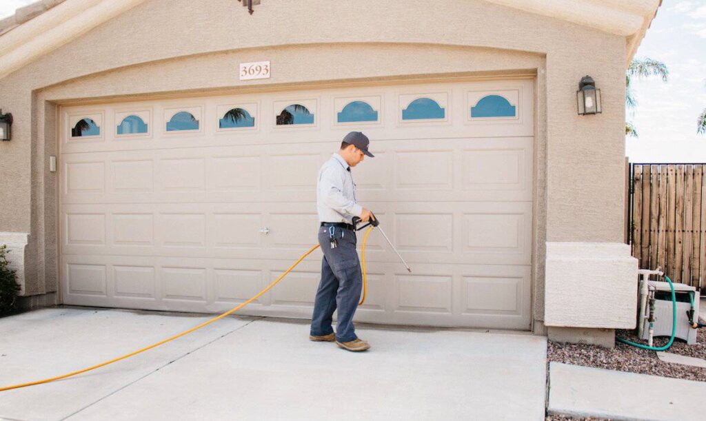 Pest control tech spraying for pests